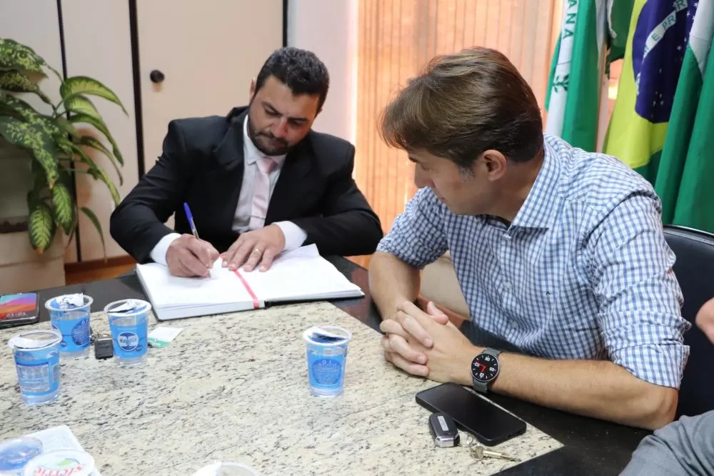 Momento em que o prefeito Adriano Backes, ao lado do então prefeito Marcio Rauber, assinava a ata de posse como prefeito. (Foto: Assessoria)