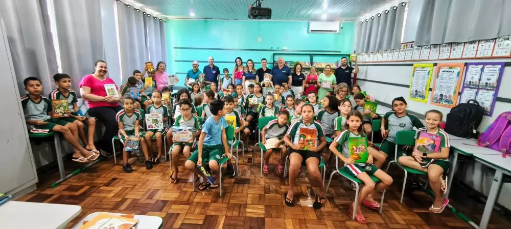 Os alunos, professores e rotarianos com os livros e jogos educativos. Foto: João Livi