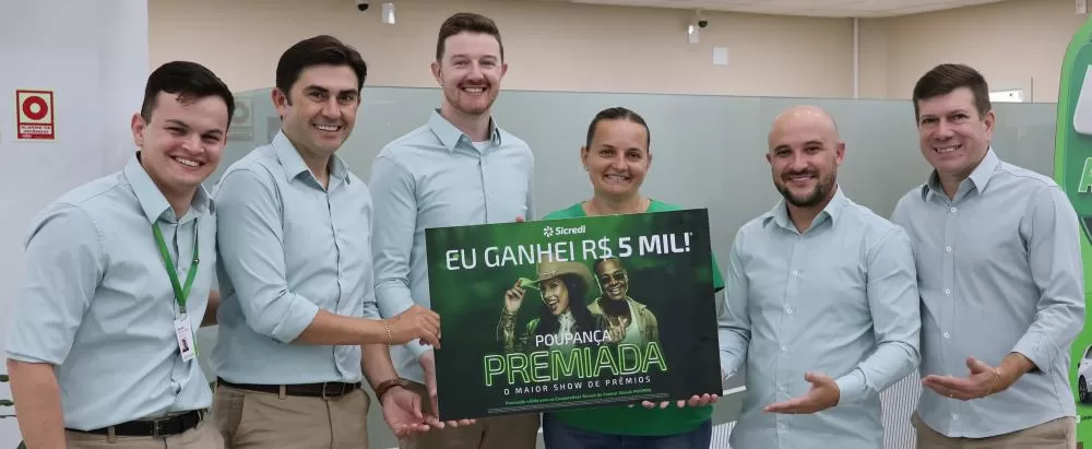 A equipe da Sicredi com a representante da APM da Escola Criança Feliz. (Foto: Assessoria/Sicredi)