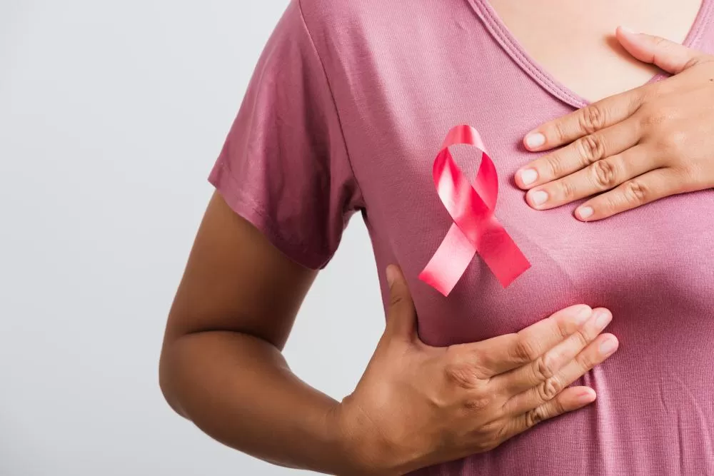 Mulher realiza o autoexame das mamas, prática essencial para o autoconhecimento corporal e a detecção precoce do câncer de mama.