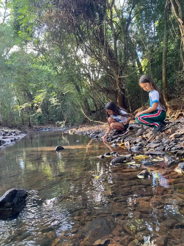 Alunos do PROÁGUA observam de perto o caminho da água durante visita a área da Estação de Tratamento de Água, em momento de conscientização ambiental às margens de um rio de água limpa. (Foto: Divulgação/SAAE)