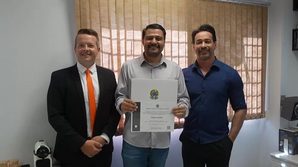 João Bersch, Fábio Fockink, com o diploma, e o chefe do cartório eleitoral durante o procedimento de retotalização dos votos em Marechal Cândido Rondon. (Foto: João Livi)