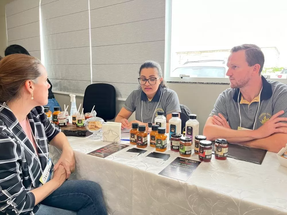 Legenda: Tiago Rener e a esposa participaram da rodada de negócios, apresentando os produtos da Fábrica Rener Pimentas a potenciais compradores. (Foto: Divulgação)