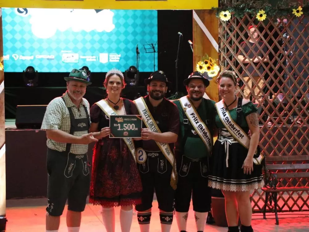 O presidente da PROEM, Júnior Paulinho Nisczcak entregou o prêmio ao casal Kátia e Marlon Hubner (Fritz e Frida da Oktoberfest de 2026), ao lado do casal Carlos e Sueli Hubner (Frtiz e Frida da Oktoberfest de 2025). (Fotos: Divulgação)