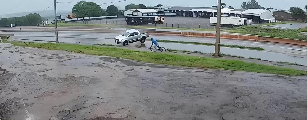 Imagem de câmera de segurança registrou o momento em que ciclista escapou por centímetros de ser atingido por camioneta na BR-163, em Marechal Cândido Rondon. (Foto: Reprodução/Metalúrgica AJJ)