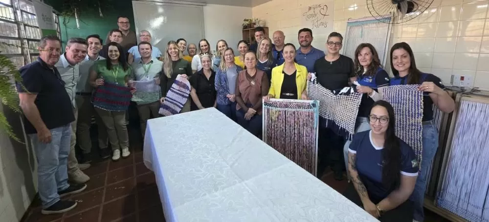 Representantes do Sicredi, Rotary, parceiros e autoridades conheceram o projeto de tecelagem e acompanharam a entrega de computadores ao CAF. (Foto: Divulgação)